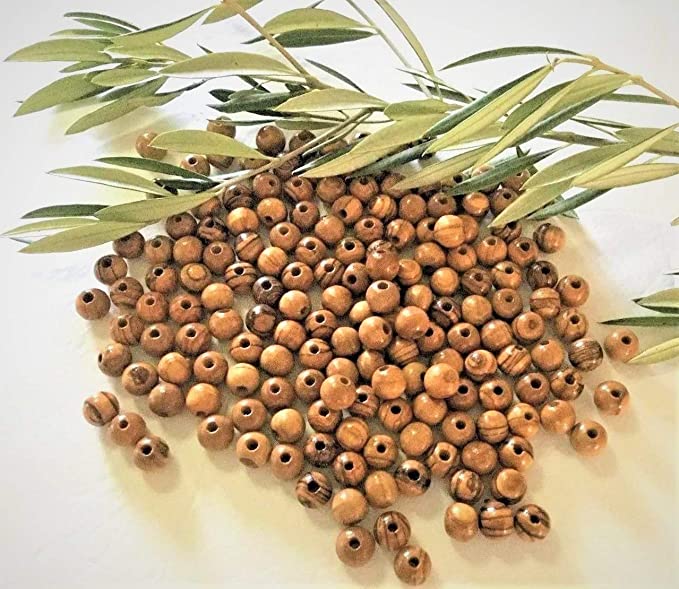 12mm Round Olive Wood Beads On A Table With Olive Branch.