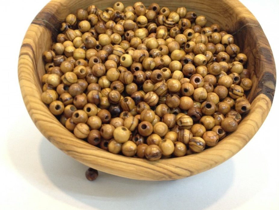 Wooden Tub In Middle Of Table With Round Olive Wood Beads From Bethlehem.