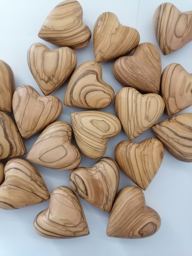 Bunch Of Hand Carved Olive Wood Hearts On Table.