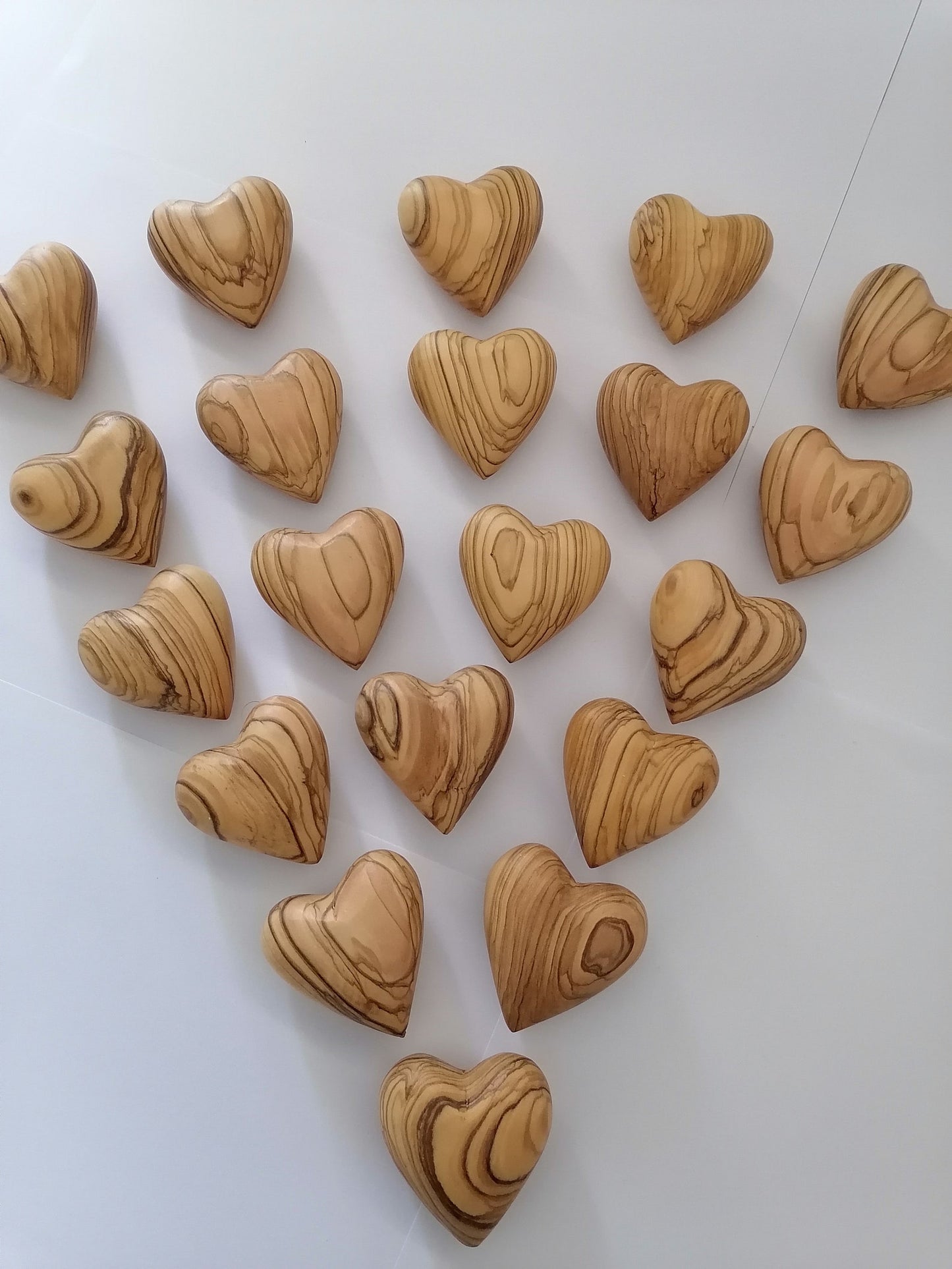 Hand Carved Olive Wood Hearts From Bethlehem Spread Out On Table.